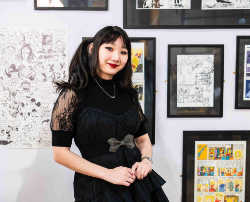 Sabrina Kaufmann posant devant l'exposition sur la BD luxembourgeoise